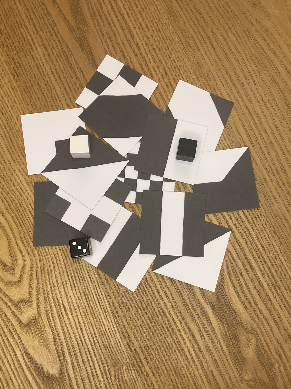 Componentes del juego CONTRAST mostrando losetas, peones y dados