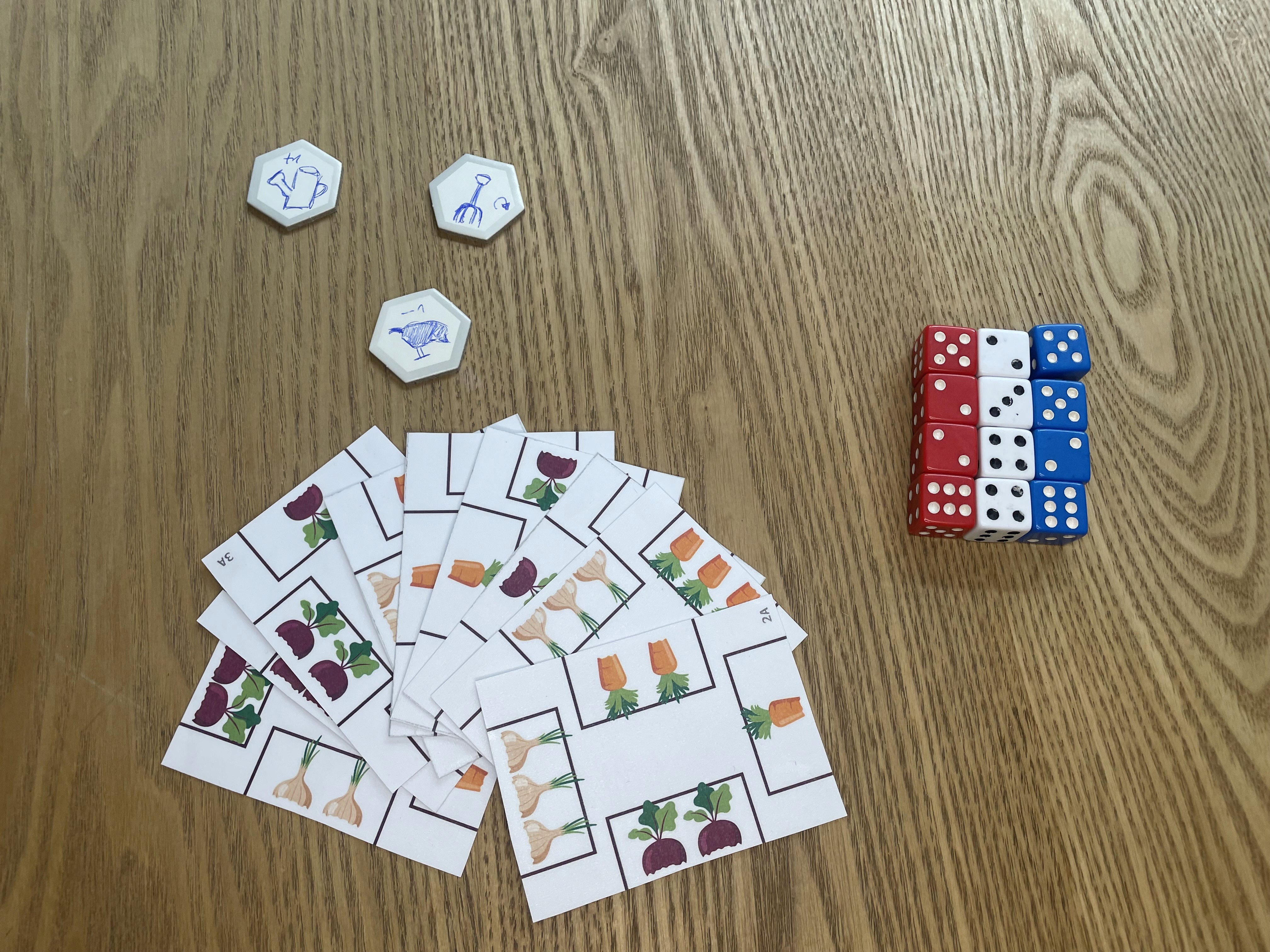 Componentes del juego Veggie Patch mostrando las cartas y la preparación con dados
